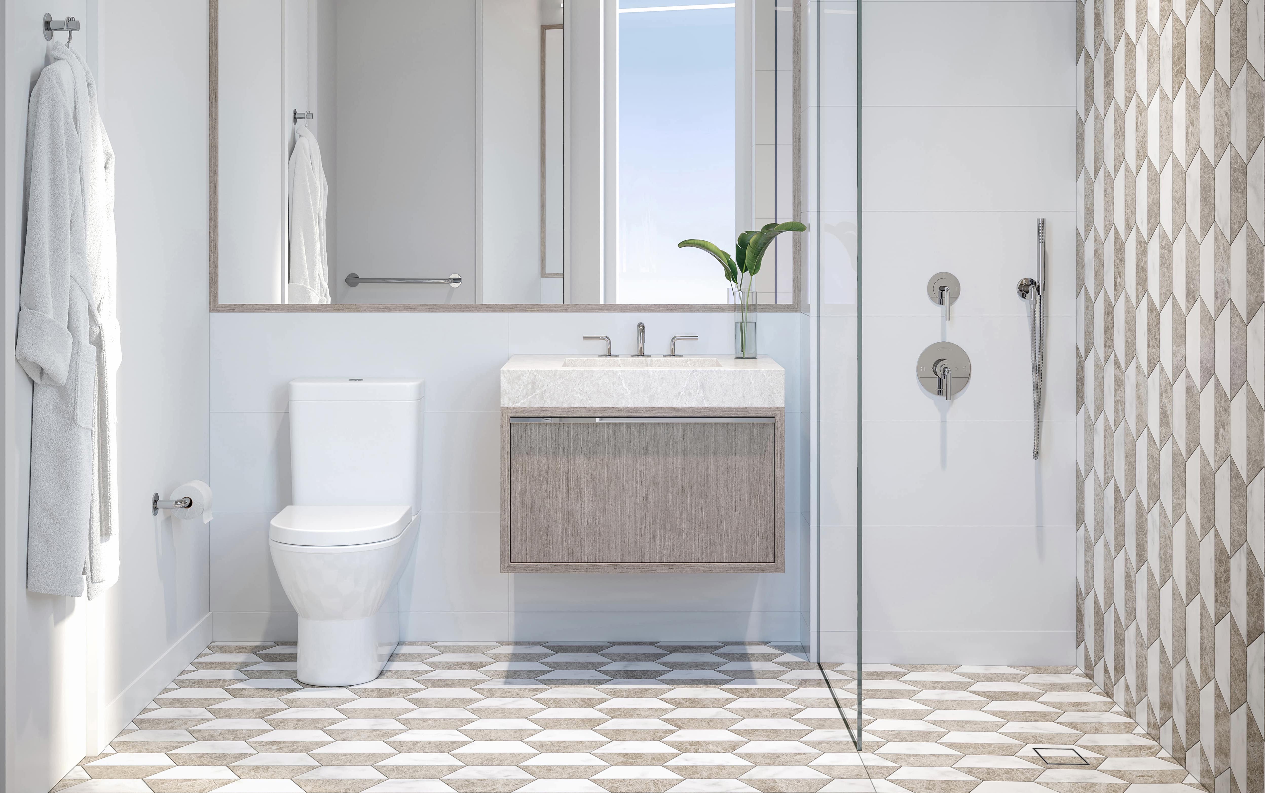 Light colored bathroom in NOVA condominiums with robe hanging on door. Sink and mirror between toilet and walk in shower.